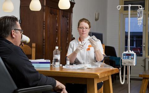 Een oncologie verpleegkundige van Icare geeft een patiënt thuis immuuntherapie.