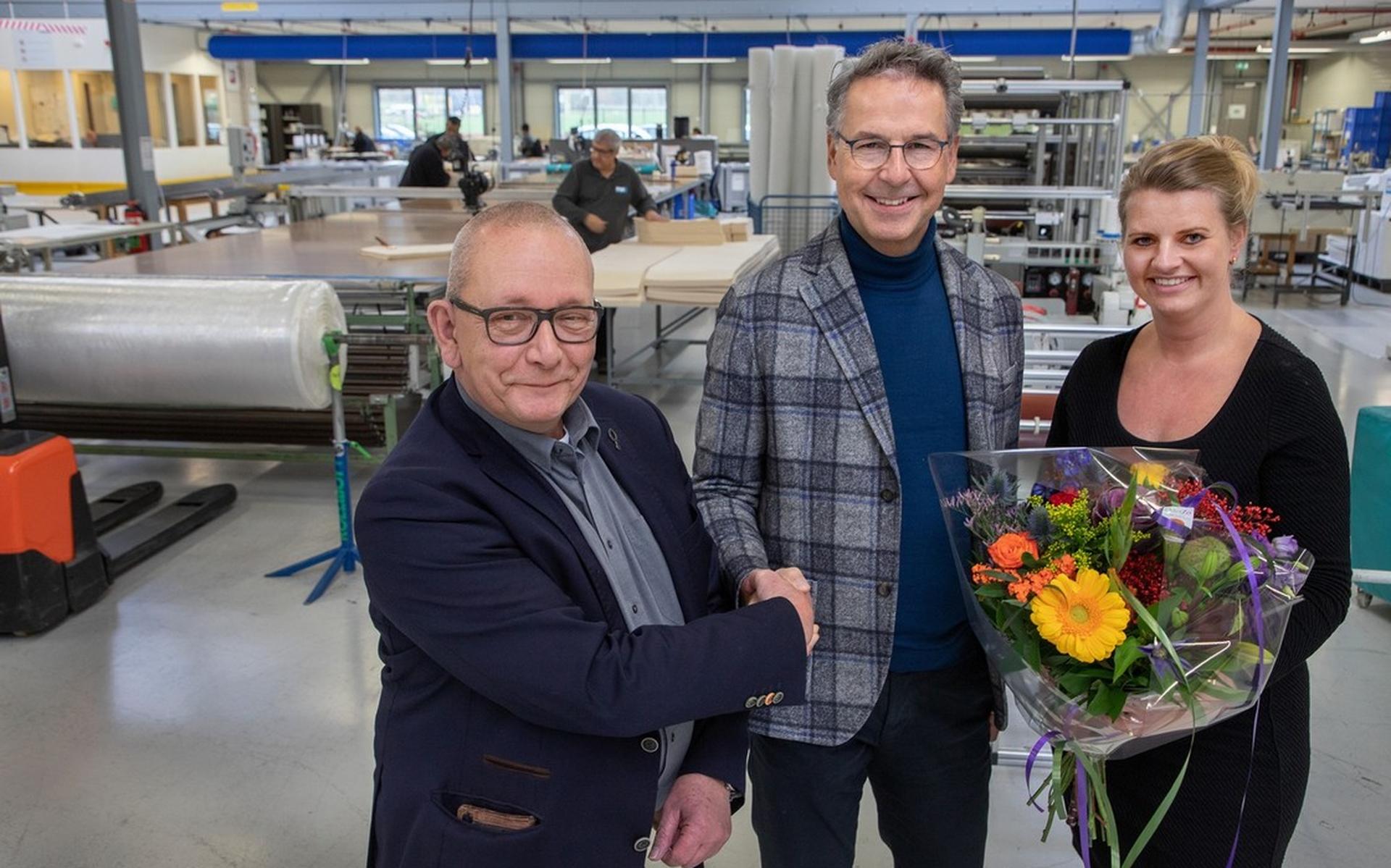 Wethouder John van den Heuvel brengt de felicitaties over aan algemeen directeur Jan Hannink en Marike van den Ham, HR Manager, van Vlint.