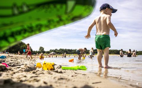 Mensen zoeken verkoeling bij het water van recreatieplas Berkendonk in Helmond. Het is op veel plaatsen tropisch warm.