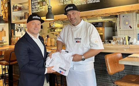 Barry Porsius van City Marketing Lelystad overhandigt aan chef Lars Dekens de koksbuizen die speciaal zijn gemaakt voor De Gordiaan kitchen-bar in verband met de finaleplaats.